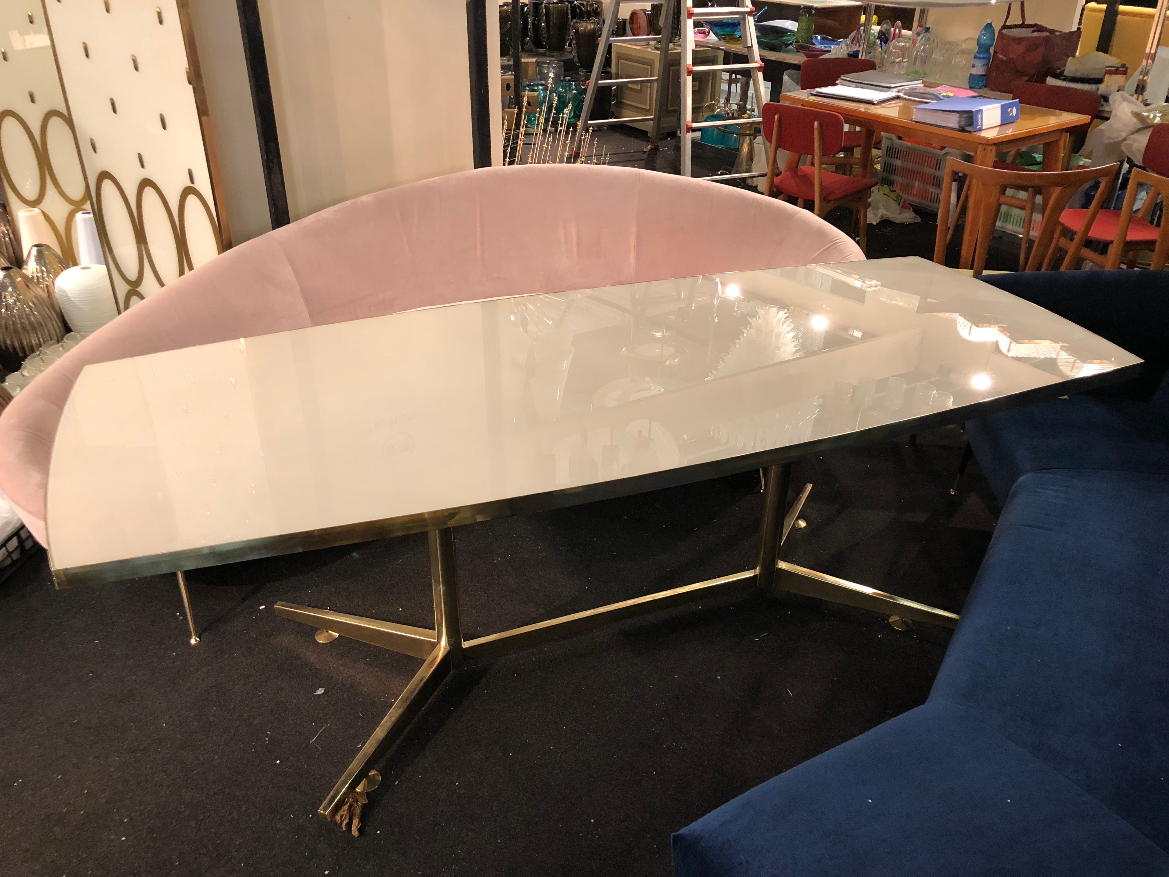 tavolo con piano in vetro bianco, forma rettangolare leggermente curvo.italia produzione recente